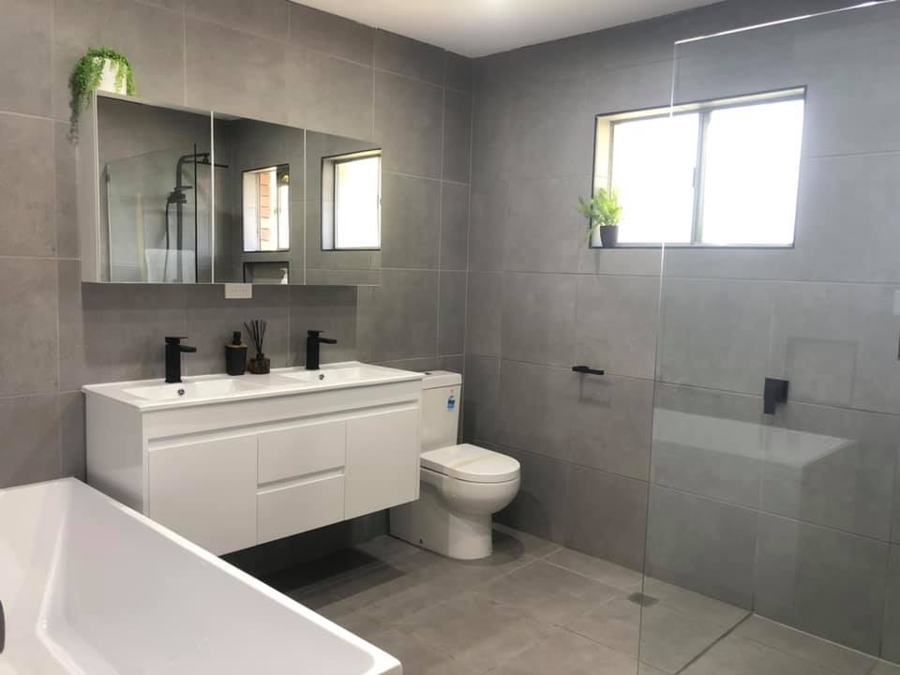 Bathroom renovation with double-basin vanity and glass shower screen