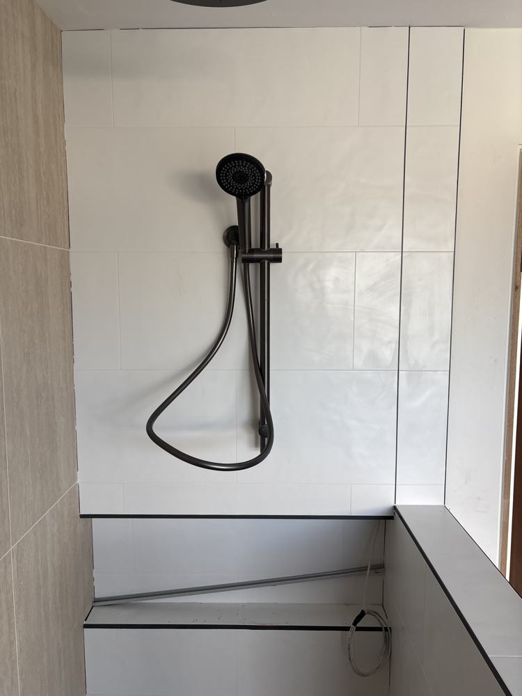 Gunmetal rail shower on white tile