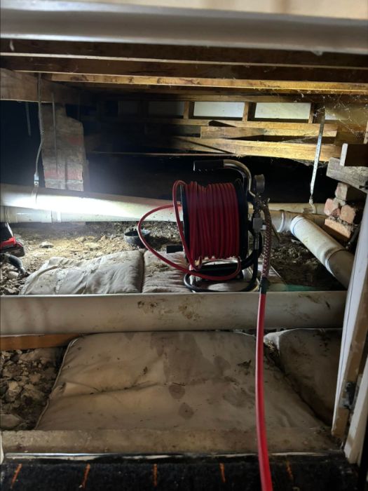 Drain inspection camera reel set up under a house