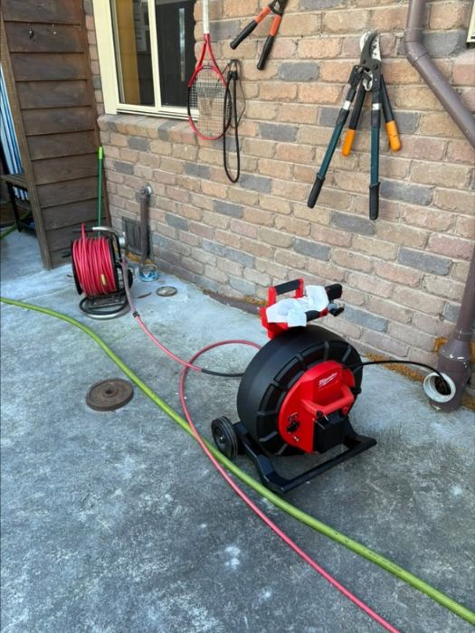 Drain inspection camera reel set up beside a house