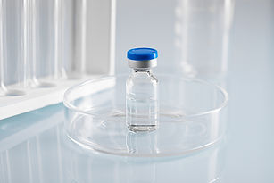 closeup-shot-closed-glass-vial-with-clear-liquid-glass-dish-lab.jpg