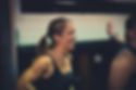 Smiling woman with a ponytail wearing a black tank top in a gym environment