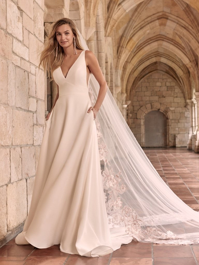 Front view of Maggie Sottero Josephine A-line crepe wedding dress with deep V-neckline and wide waist band