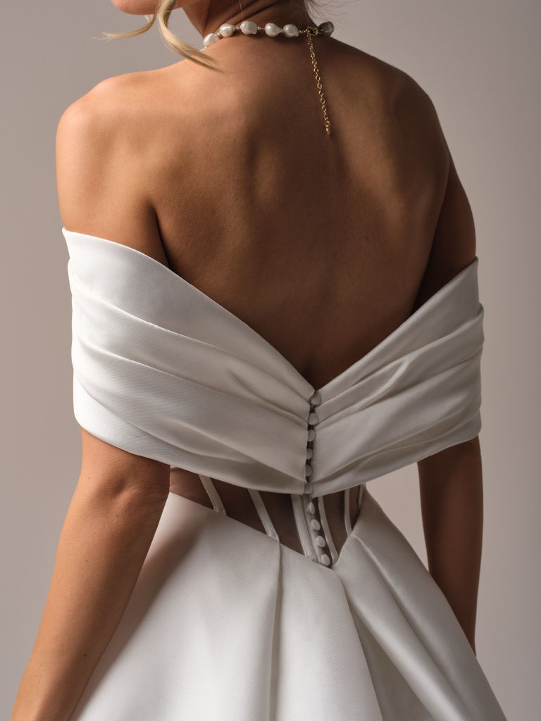 Thumbnail: Close up of back of Rebecca Ingram Brooke Timeless tie bodice Mikado A-line bridal gown with off-shoulder cap sleeve