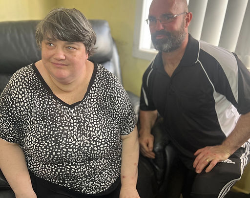 Woman with disability sitting on chair with male support worker