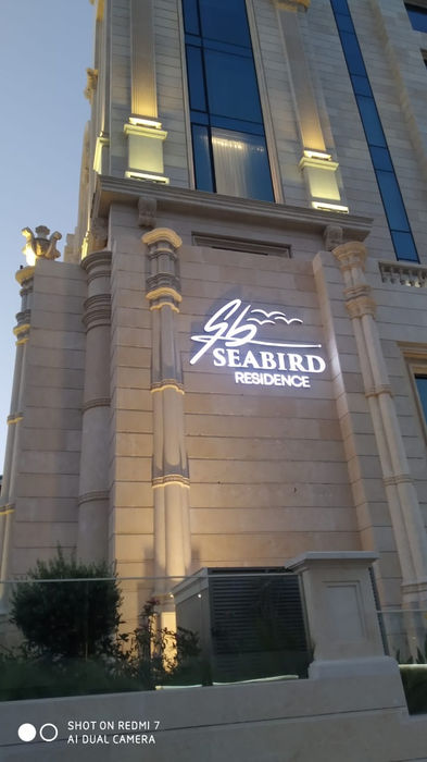 Luxury hotel tower with illuminated exterior branding and logo signage