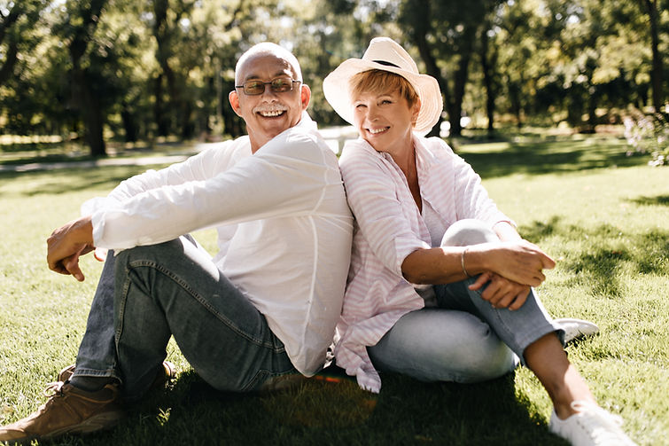 positive-lady-with-cool-hat-in-striped-stylish-blouse-and-jeans-smiling-and-sitting-on-gra