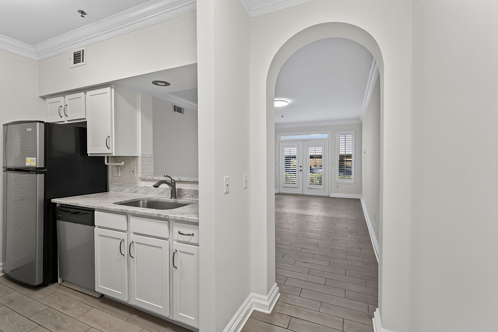 Modern kitchen with white cabinets and arched doorway