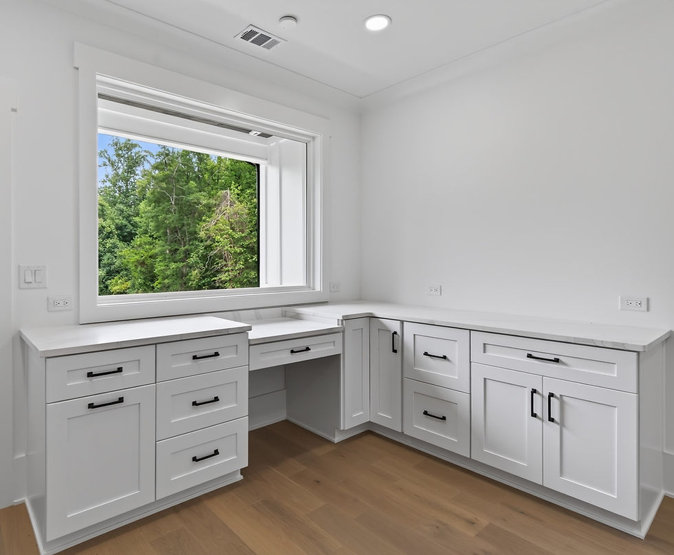 White home office cabinets and desk under a window.