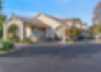 Modern commercial building with porte-cochere and parking.