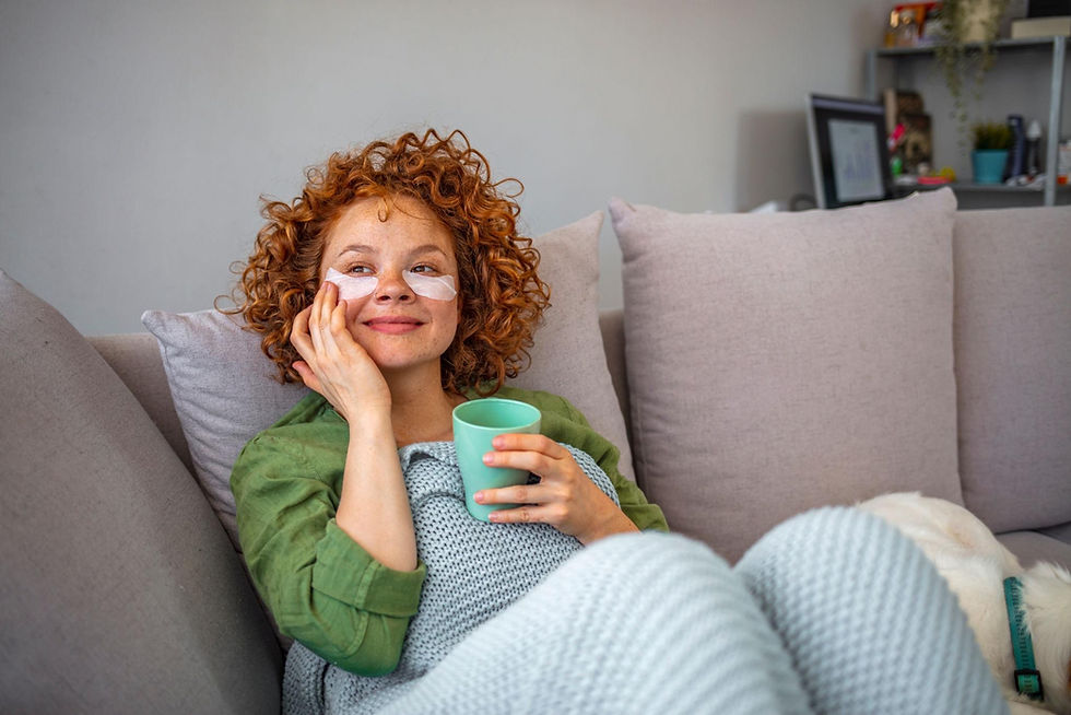 Woman relaxing on a sofa with a warm drink as part of an evening de stress routine to unwind, reduce stress, and support emotional wellbeing at home.