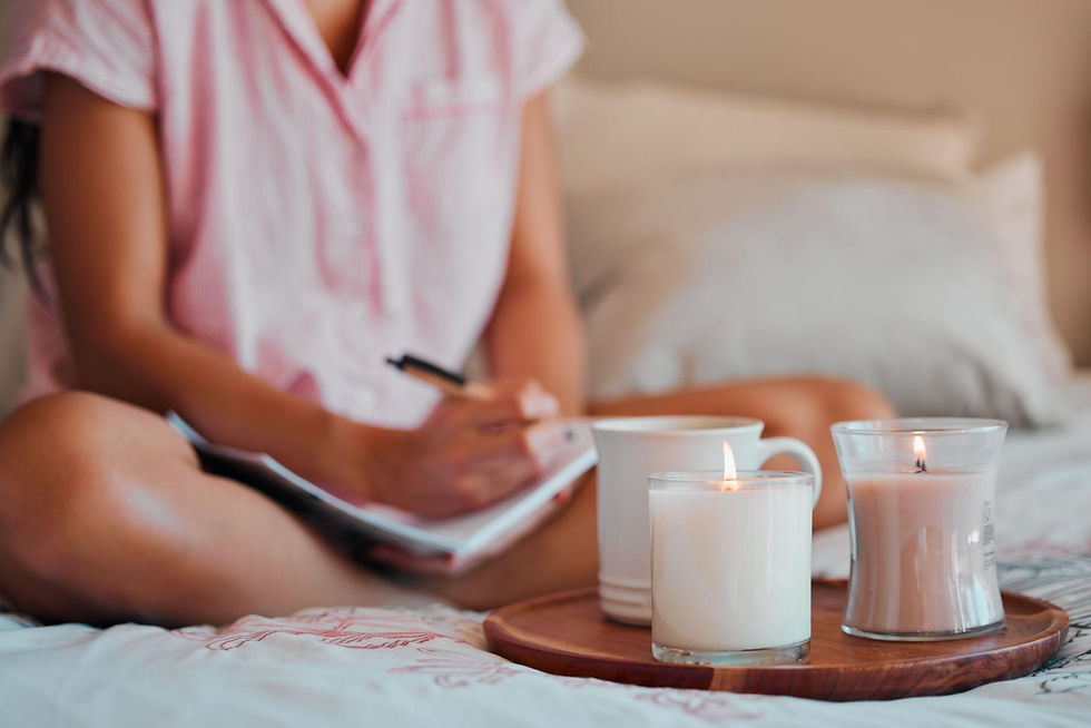 Person writing tomorrow’s to-do list beside a warm drink and candle, demonstrating how to relieve stress quickly at home through mental decluttering.