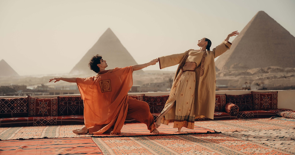 Performers dancing in Egypt in view of the Pyramids