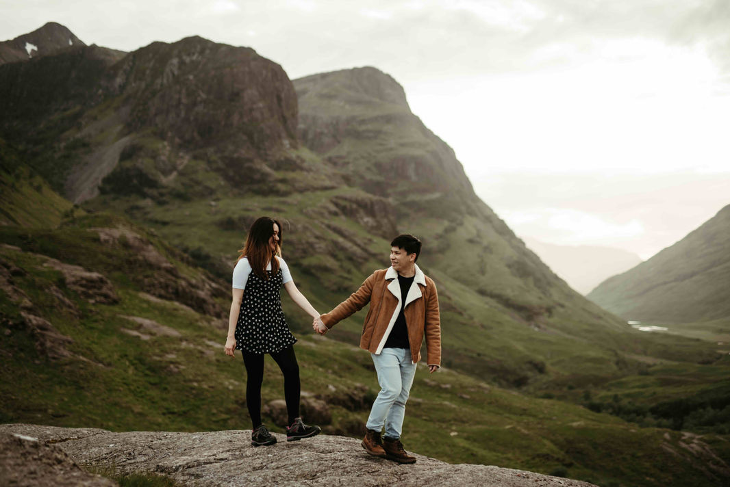 A couple walking and exploring Glencoe and the Three Sisters.