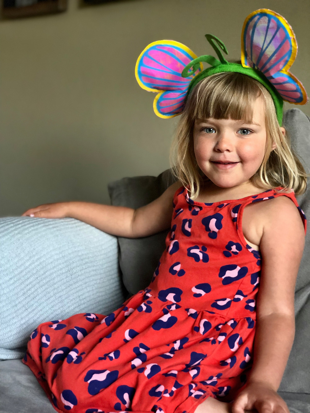 little girl wearing red dress and butterfly headband