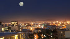 cityscape image at night, with a full moon