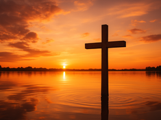 A wooden cross stands in calm water at sunset, with an orange sky and silhouetted trees. The mood is serene and reflective.