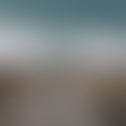 A person in shorts stands on a dirt road facing a stormy sky, watching a lightning bolt. Vast field under ominous dark clouds.