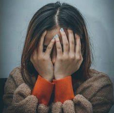 woman in distress covering her face with her hands