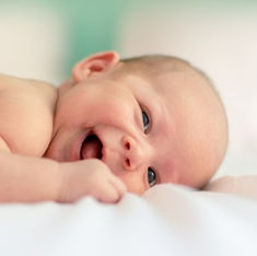 picture of baby laying on their side smiling