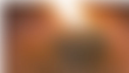 Abstract image of spiraling grooves with a bright light in the center. The pattern creates a hypnotic effect with warm orange tones.