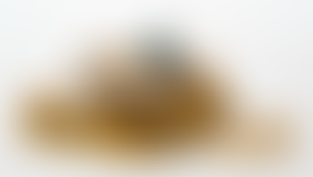 A tiny figure in a blue suit reads a newspaper, sitting on a stack of gold coins against a white background, conveying financial focus.