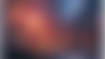 A lone figure stands on a hill, gazing at a vibrant swirling nebula of orange and blue in the night sky, evoking a sense of wonder.
