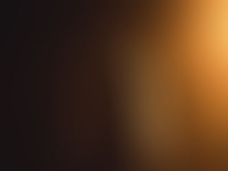 Silhouetted woman with long hair backlit by warm orange light against a dark background, creating a dramatic glow.