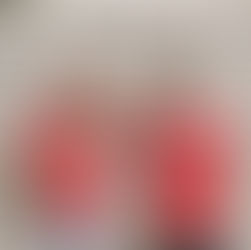 Two people in red "thankful" shirts smile and laugh. Background features white shutters. One wears a red bandana and denim shorts. Mood is joyful.