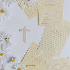 A wooden cross, daisies, and torn notes with "Burdens," "Depression," and "Anxiety" on a white background convey hope and struggle.