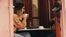 women sitting in coffeeshop having coffee with a friend