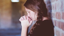 woman praying in a hall way