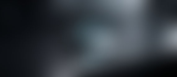 Macro shot of a matte black titanium smart ring and a minimalist white CGM sensor on a dark slate surface, illustrating passive biometric intelligence and wearable tech.