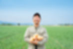 宮尾オーナーが笑顔でたまねぎを抱えている
