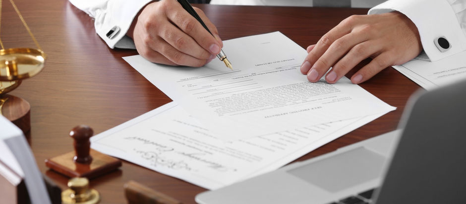 Person signing legal documents at a desk with notary tools