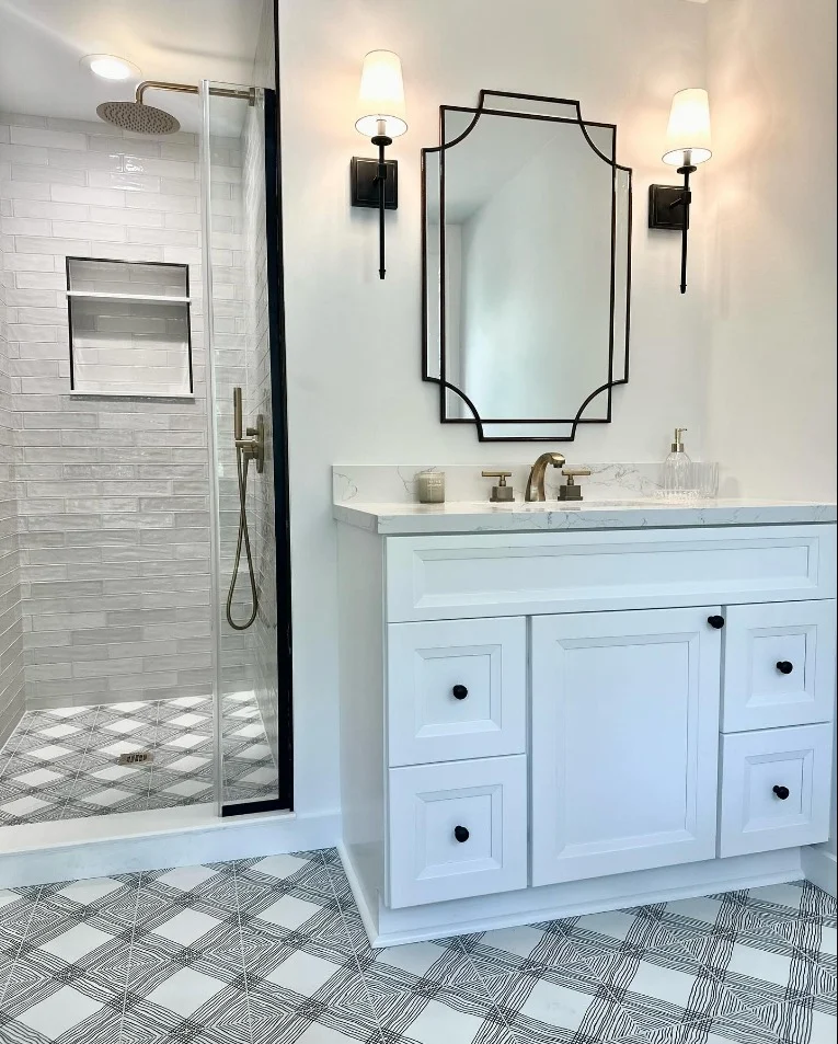 Bathroom remodel with custom white vanity, decorative mirror, and tiled walk-in shower in Summerville SC