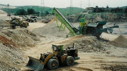 A tractor digs in the ground and behind it is a large conveyor belt and a soil filtering system
טרקטור חופר באדמה ומאחוריו מסוע גדול ומערכת סינון אדמה