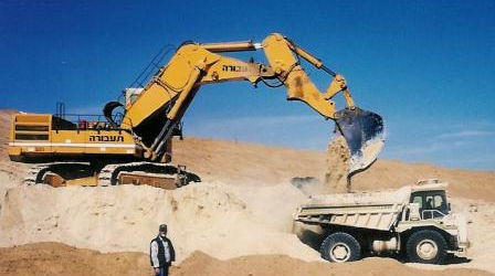 An excavator loads soil into a truck
מחפר מעמיס אדמה לתוך משאית