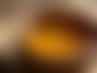 A wooden bowl with honey being poured in