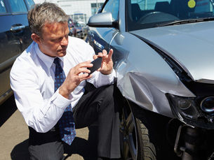 Loss Adjuster Inspecting Car Involved In Accident