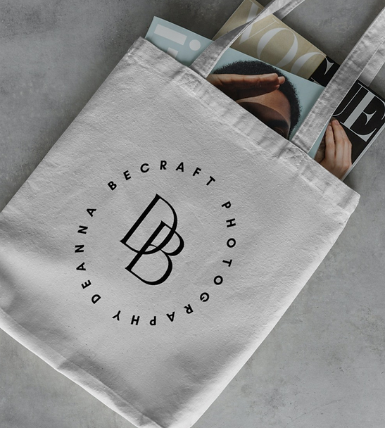 deanna becraft photography logo mark displayed beautifully on a neutral canvas tote with magazines sticking out of it