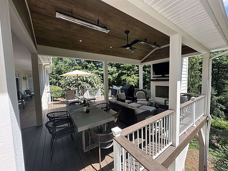 Modern covered deck with dining table and outdoor fireplace