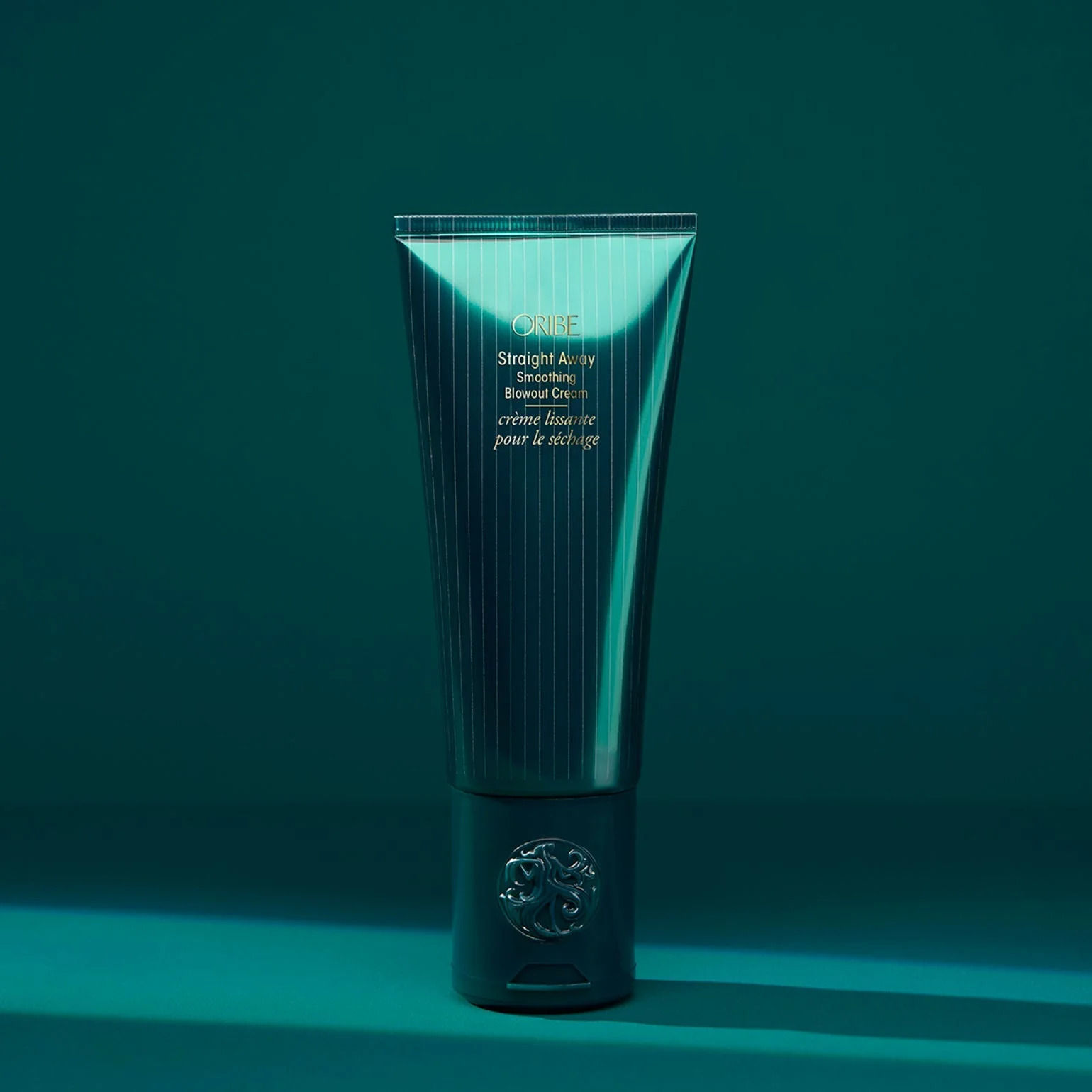 Tube of Oribe Straight Away Smoothing Blowout Cream in teal‑green packaging, tube style