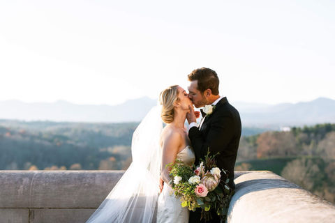 Husband and wife just married kissing at the Biltmore Estate
