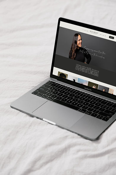 Deanna Becraft Photography Website on laptop that's sitting on a white bed