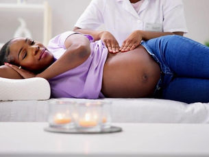 Doula offering quiet support to a birthing person during labor; Calm presence of doula holding space for expectant mother in San Diego hospital; Birthing woman resting while doula provides emotional support; Partner and doula together supporting a mother during birth journey