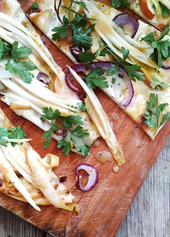 Chicorée Flammkuchen Marinierter Honig-Senf Chicorée auf Zitronencreme mit Apfel, Zwiebeln und frischer Petersilie