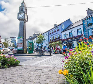 A street with clock tower and colourful builidings