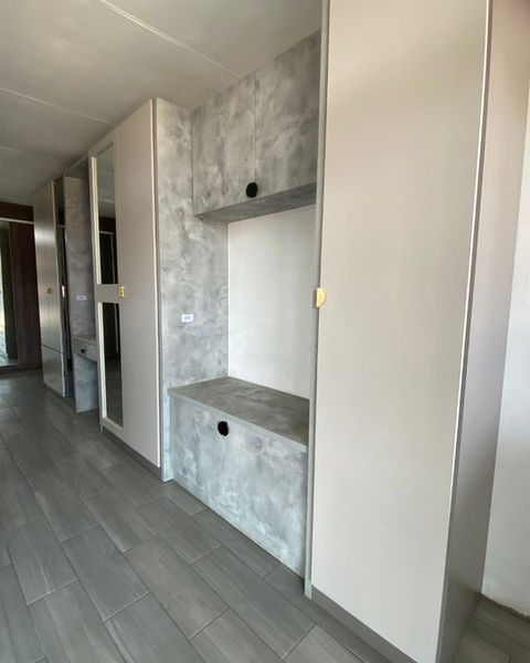 Our showroom BIC with cotton texture doors, basalt texture carcasses and elmina stucco feature units in between. Handles are black and brushed brass cup handles. A mirror cut-out unit and a tinted glass door shelving unit stand out along side a vanity and window nook.