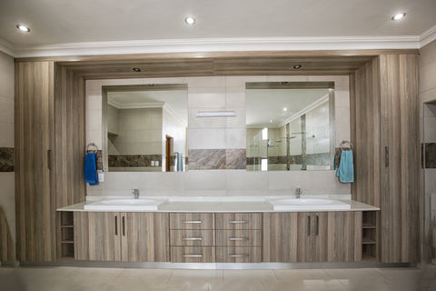 Woodgrain melamine bathroom vanity unit with tall units and open shelving display units either side, complete with a quartz countertop.